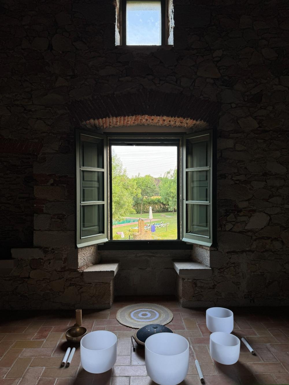 Cuencos tibetanos junto a una ventana con vistas al jardín