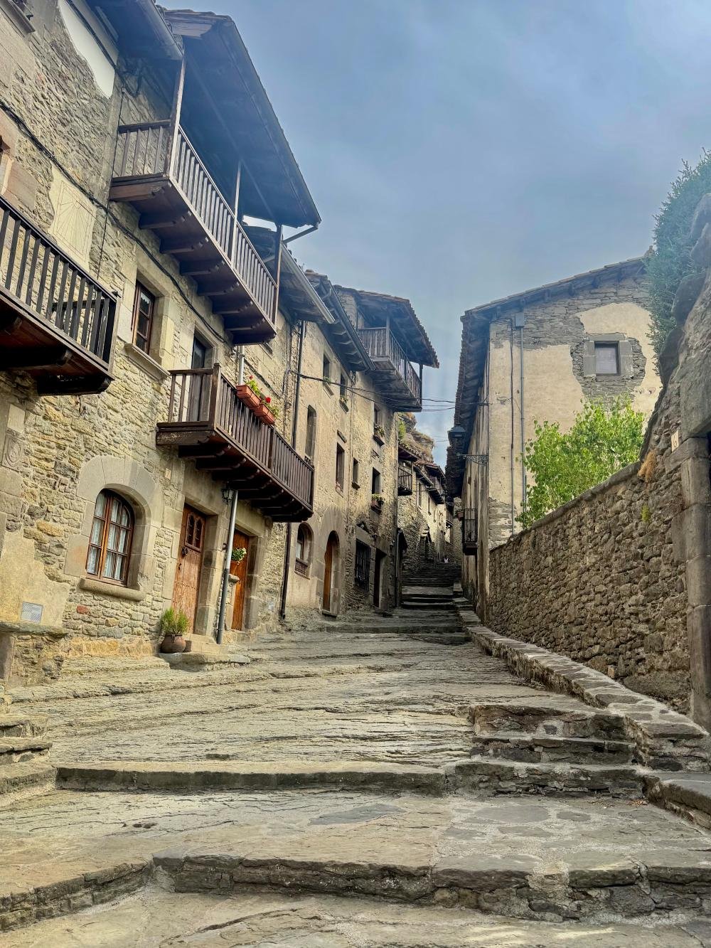 Calle empedrada y balcones de madera en el casco antiguo de Rupit